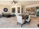 Inviting outdoor patio with a ceiling fan, a dining area, and a comfortable seating area with a fire pit at 7864 Grande Shores Dr, Sarasota, FL 34240