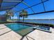 Screened in pool with lake view and a built-in spa offers an amazing outdoor living experience at 7864 Grande Shores Dr, Sarasota, FL 34240