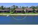 Back exterior view of house from over water with screened patio and lush lawn at 7864 Grande Shores Dr, Sarasota, FL 34240