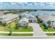 Aerial view of beautiful home by lake with lush landscaping and brick driveway at 8067 Waterbend Trl, Sarasota, FL 34240
