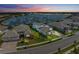 Areal view of the home on a street by the lake at sunset at 8067 Waterbend Trl, Sarasota, FL 34240