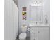 Bathroom featuring a white vanity, elegant lighting, and a decorative shower curtain at 8067 Waterbend Trl, Sarasota, FL 34240