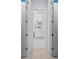 Bathroom view featuring an entrance between two doors that leads into a bright area with white cabinets and mirrors at 8067 Waterbend Trl, Sarasota, FL 34240