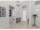 Bright foyer featuring modern chandelier, transom window, and wood-look tile flooring at 8067 Waterbend Trl, Sarasota, FL 34240