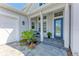 Inviting front porch featuring a charming blue door, a bench, and colorful flowerpots at 8067 Waterbend Trl, Sarasota, FL 34240