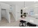 Bright kitchen with a large island, breakfast bar seating, white cabinets, and stainless appliances next to the stairwell at 8067 Waterbend Trl, Sarasota, FL 34240
