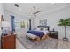 A serene primary bedroom with tray ceilings, a ceiling fan, lake views, and elegant furnishings at 8067 Waterbend Trl, Sarasota, FL 34240