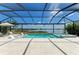 Screened pool and spa with lounge chairs overlooking a serene lake at 8067 Waterbend Trl, Sarasota, FL 34240