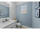 Stylish powder room featuring textured walls, modern fixtures, and elegant framed artwork at 8067 Waterbend Trl, Sarasota, FL 34240