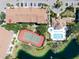 Aerial view featuring a tennis court, swimming pool, and community amenities surrounded by lush landscaping and water features at 850 S Tamiami Trl # 836, Sarasota, FL 34236