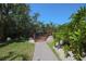 Picturesque walkway to a wooden deck, framed by vibrant greenery and a clear blue sky at 850 S Tamiami Trl # 836, Sarasota, FL 34236