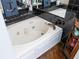 Bright bathroom showcasing a modern soaking tub with black tile surround and sleek fixtures at 861 Nectar Rd, Venice, FL 34293