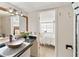 Bright bathroom featuring a modern vessel sink, wood-trimmed mirror, and an open view into the adjacent bedroom at 861 Nectar Rd, Venice, FL 34293