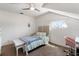 Cozy bedroom with a ceiling fan, neutral colors, and natural light from a large window at 861 Nectar Rd, Venice, FL 34293