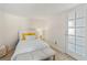 Cozy bedroom with white bedding, accent pillows, and a frosted glass door, providing a serene and private retreat at 861 Nectar Rd, Venice, FL 34293