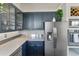 Well-equipped kitchen with stainless steel refrigerator, microwave, and dark blue cabinets at 861 Nectar Rd, Venice, FL 34293