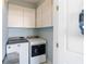 Laundry area with washer, dryer, and overhead cabinets at 861 Nectar Rd, Venice, FL 34293