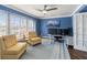 Cozy home office featuring blue walls, bright windows, and comfortable seating at 861 Nectar Rd, Venice, FL 34293