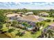 A stunning aerial view of a home with a screened-in pool and lush landscaping at 8712 Grey Oaks Ave, Sarasota, FL 34238