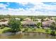 Aerial view of the property with screened lanai, pool and lush landscaping by the lake at 8712 Grey Oaks Ave, Sarasota, FL 34238
