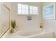 Bright bathroom featuring a soaking tub under a window at 8712 Grey Oaks Ave, Sarasota, FL 34238