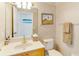 Cozy bathroom featuring wallpaper, a vanity with a framed mirror, and decorative accents like lighthouse art at 8712 Grey Oaks Ave, Sarasota, FL 34238