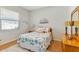 Guest bedroom with a beachy theme, featuring a bed with seashell pattern quilt, and hardwood floors at 8712 Grey Oaks Ave, Sarasota, FL 34238