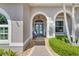 Inviting entryway with arched openings, paver flooring, and a charming blue double door at 8712 Grey Oaks Ave, Sarasota, FL 34238