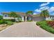 Charming front exterior featuring a paver driveway, lush landscaping, and a welcoming entrance at 8712 Grey Oaks Ave, Sarasota, FL 34238