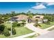 An inviting home with a well-manicured lawn, lush landscaping and a circular paver driveway at 8712 Grey Oaks Ave, Sarasota, FL 34238