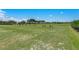 Scenic golf course featuring a practice area with manicured grass and distant trees under a blue sky at 8712 Grey Oaks Ave, Sarasota, FL 34238