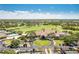A bird's-eye view of the golf course with a clubhouse, swimming pool, and parking area at 8712 Grey Oaks Ave, Sarasota, FL 34238