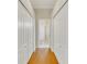 Hallway featuring a wood floor and white closet doors leading to bathroom with glass shower at 8712 Grey Oaks Ave, Sarasota, FL 34238