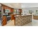 Well-lit kitchen featuring stainless steel appliances and a stone-accented breakfast bar at 8712 Grey Oaks Ave, Sarasota, FL 34238