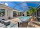 Inviting backyard pool and patio with comfortable seating and a covered lanai at 8712 Grey Oaks Ave, Sarasota, FL 34238