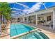 Backyard pool with a screened lanai, spa and inviting lounge chairs for relaxation at 8712 Grey Oaks Ave, Sarasota, FL 34238