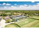 Aerial view of tennis courts, a golf course, and manicured landscaping, providing a recreational lifestyle at 8712 Grey Oaks Ave, Sarasota, FL 34238