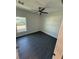 Bright bedroom with modern gray flooring, a ceiling fan, and large window at 8810 1/2 N Mulberry St, Tampa, FL 33604