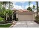 Charming single-Gathering home with a beige exterior, arched entrance, and well-maintained landscaping at 11274 Beebalm Cir, Lakewood Ranch, FL 34202
