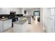 Open kitchen with granite countertops, white cabinets, stainless steel appliances, and an eat-in island at 11274 Beebalm Cir, Lakewood Ranch, FL 34202