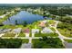 Aerial view of home with lake access, screened pool, and manicured lawns in a residential neighborhood at 11895 Claremont Dr, Port Charlotte, FL 33981