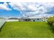 A lush green lawn with a screened-in pool stretches to a privacy fence at 11895 Claremont Dr, Port Charlotte, FL 33981