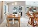 Bright dining area with a wood table and white chairs next to sliding glass doors to the screened patio at 11895 Claremont Dr, Port Charlotte, FL 33981