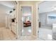 Hallway showing the kitchen, and two bedrooms with tile flooring leading to a bedroom with a queen size bed at 11895 Claremont Dr, Port Charlotte, FL 33981