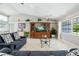 Bright living room with vaulted ceilings, neutral walls, tile flooring, and large entertainment center at 11895 Claremont Dr, Port Charlotte, FL 33981
