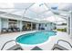 The enclosed backyard features a pool with a patio that holds dining and lounge furniture at 11895 Claremont Dr, Port Charlotte, FL 33981