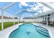 Inviting screened-in pool with tile accents, lounge chairs, and spacious patio for outdoor relaxation at 11895 Claremont Dr, Port Charlotte, FL 33981