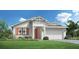 Charming single-story home with a manicured lawn, orange shutters and a two-car garage at 12876 Morning Mist Pl, Venice, FL 34293
