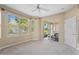 Spacious carpeted bedroom featuring a ceiling fan, large windows, and a sliding glass door to the lanai at 1363 New Forest Ln, Osprey, FL 34229