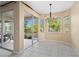 Bright dining area with tile flooring, a stylish chandelier, and expansive sliding glass doors that lead to a screened lanai at 1363 New Forest Ln, Osprey, FL 34229